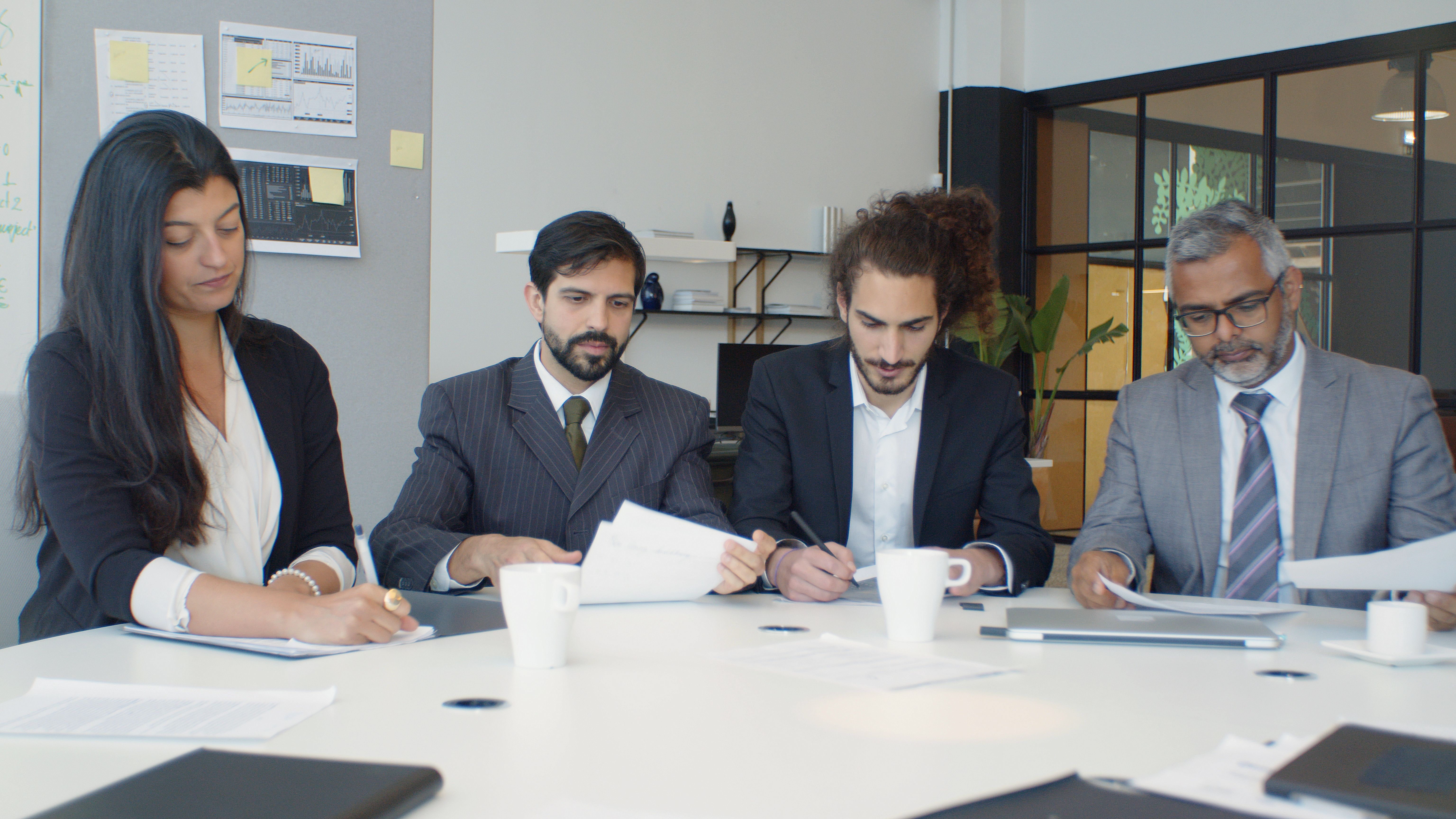 Picture of woman and three men conducting a panel interview, from the perspective of the interviewee.